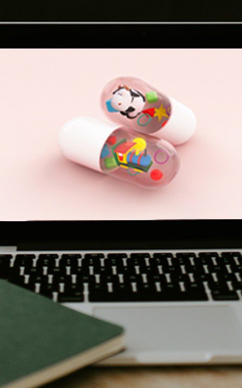ordenador portátil con píldoras en la pantalla